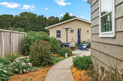 Looking to the backyard at one of 2 patio spaces, the garage and the bonus bungalow above the garage.