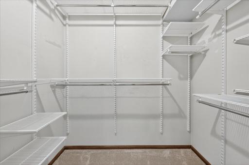 The primary closet features a wonderful Elfa custom closet organizing system.