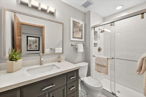 WOW, you'll love the primary bath remodel that was completed in 2022. Enjoy a newer vanity with soft close doors and drawers, Quartz countertops, a tiled shower and floor an updated mirror and fixtures.
