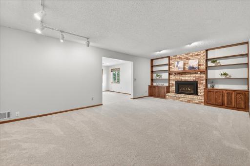 Retreat to the lower level where you'll find a big family room that boasts a gas fireplace and some nice bookshelves for storage. The room to the back is directly under the sunroom and was part of the addition.