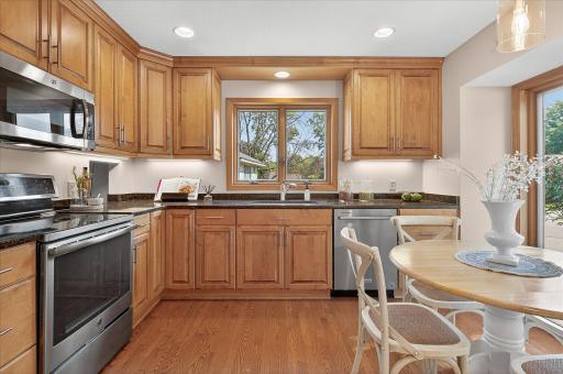 The kitchen boasts hardwood floors, maple cabinetry with soft close doors and drawers, granite countertops, under cabinet lighting and SS appliances.