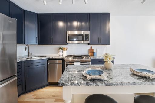Welcome to this sleek condo that knows how to make an entrance. Packed with upgrades and quality finishes, it features an open layout, bold navy kitchen, hardwood floors, and modern vibes throughout. Turnkey, stylish, and just minutes from downtown.