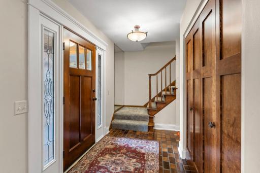 Foyer/entry area with tile floor, beautiful paneled front door and entry closet doors