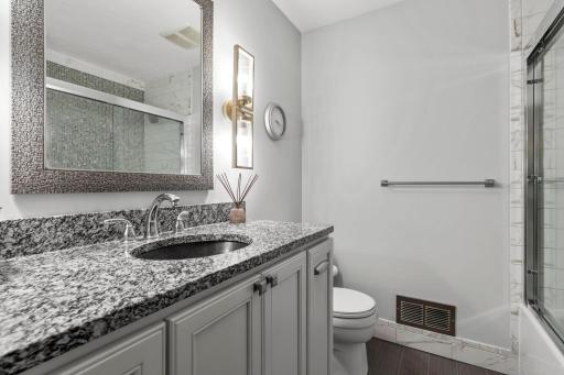 Upper full bath with beautiful tiled floor and stunning tiled tub surround, ( see it thought the mirror reflection)