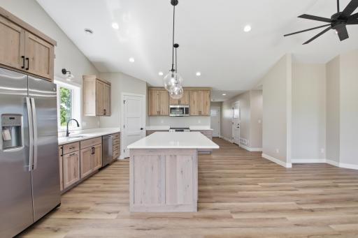 The open-concept kitchen, dining area, and living room create a spacious gathering place where family and friends can connect, entertain, and make lasting memories.