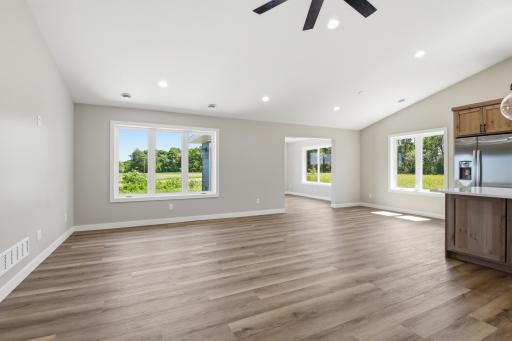 Large windows fill the main living spaces with natural light while offering beautiful views of the expansive backyard and surrounding landscape.