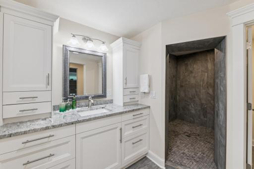 Primary bath with framed mirrors & granite tops