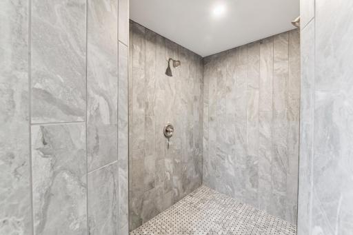 Primary walk-in tile shower with dual shower heads