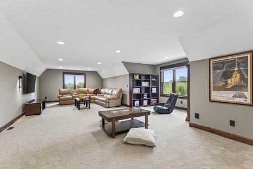 The fourth upper-level bedroom offers versatile use, serving seamlessly as a bedroom or a stylish bonus space perfect for play, study, or quiet retreat.
