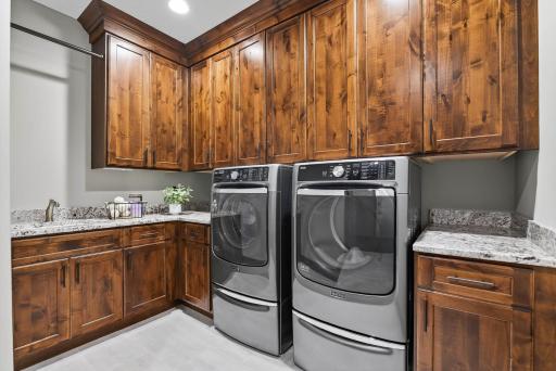 Completing the upper level is a fully finished laundry room, designed with everyday ease in mind. Outfitted with Maytag washer and dryer, abundant cabinetry, counterspace, and a sink, it ensures that functionality extends throughout the entire floor.