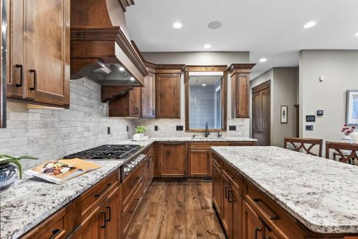 Inside, the suite features a custom kitchen with a cooktop, wall oven, warming drawer, and pantry. It opens to a sun-filled living room centered around its own gas fireplace.