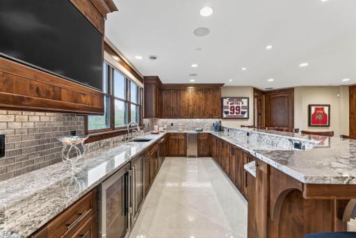 Additional highlights include a Thermador dishwasher, beverage fridges, icemaker, and filtered water system.