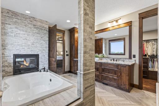 A spa-like experience awaits in the private ensuite with heated tile floors, a deep soaking tub, and dual vanities.