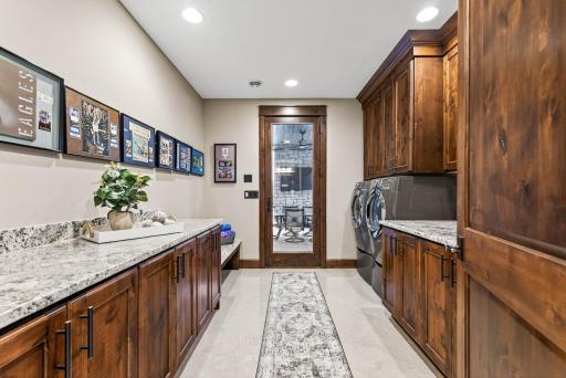 The lower level features a second laundry room with walkout access to the pool deck, along with ample storage options. A versatile utility area with a partial concrete ceiling and walls offers the potential to be enclosed as a future safe room.