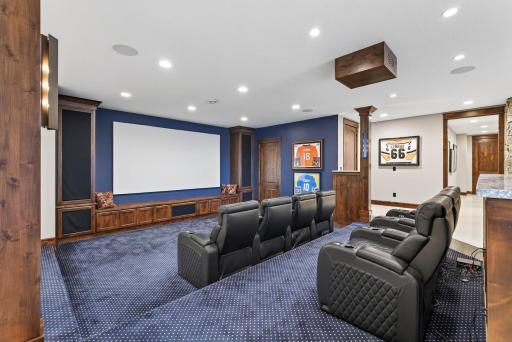 Just beyond, a tiered home theater offers plush carpeting, mood lighting, and a 150-inch projection screen.