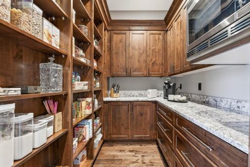 A walk-in pantry and nearby beverage station bring everyday ease.