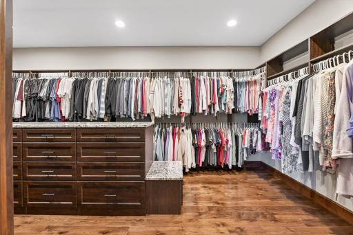 The expansive walk-in closet enhances everyday living with a center island, custom built-ins, and thoughtful touches like a pull-out ironing station and built-in hamper.