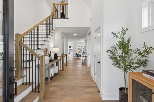 Step through a dramatic vaulted foyer with soaring 19-foot ceilings, where bespoke iron railings and architectural detailing set the tone for refined elegance.