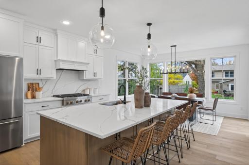 The gourmet kitchen is a true showpiece, featuring double ovens, a gas cooktop, premium stainless steel appliances, and an oversized island perfect for entertaining.