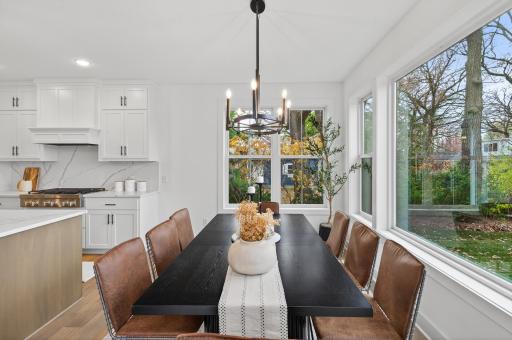 The kitchen flows effortlessly into a bright, sunlit dining area with direct access to the back patio, offering an inviting space for everyday gatherings.