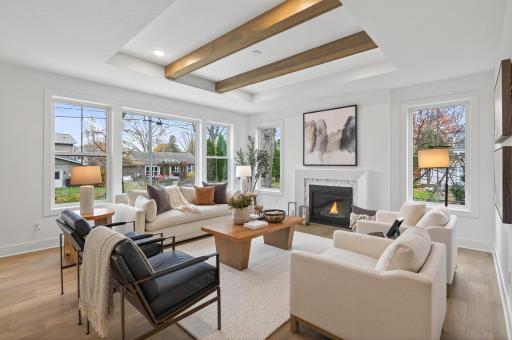 Adjacent, the great room exudes warmth and character with its gas fireplace and striking exposed wood beams.