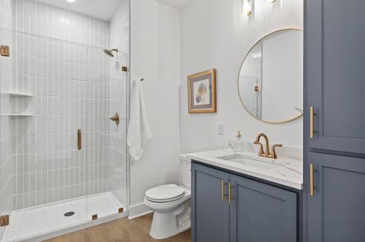 A stylish main-floor Â¾ bath features a custom tiled shower and designer finishes for a polished, modern look.