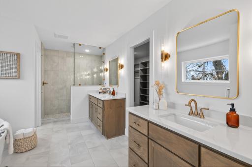 The spa-inspired ensuite bath is a serene retreat, complete with heated floors, dual vanities, a deep soaking tub, and a glass-enclosed tiled showerâcreating an atmosphere of indulgent comfort and timeless design.