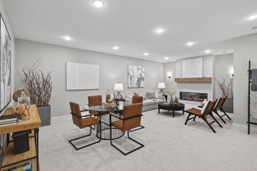The spacious lower-level family room offers the perfect blend of comfort and sophistication, featuring an elegant electric fireplace that creates a warm, inviting ambiance.