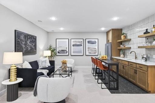 Adjacent to the family room, the stylish wet bar makes a striking statement with its eye-catching hexagon tile flooring, sleek quartz countertops, and custom cabinetryâan artful combination of design and function that elevates every occasion.