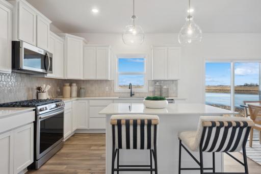 (Photos of model home, finishes will vary) The spacious kitchen features brand-new stainless steel appliances, a center island and ample cabinetry storage.
