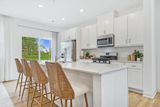 (Photo of decorated model, actual home's finishes will vary) Spacious kitchen opens to the patio.