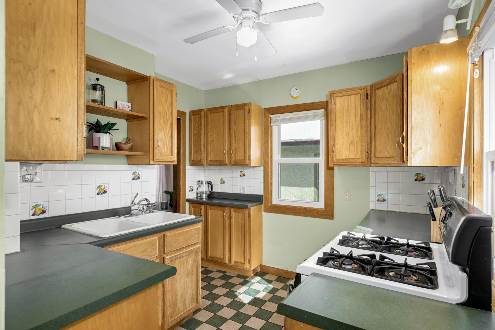 Functional kitchen with checkerboard flooring and oak cabinets