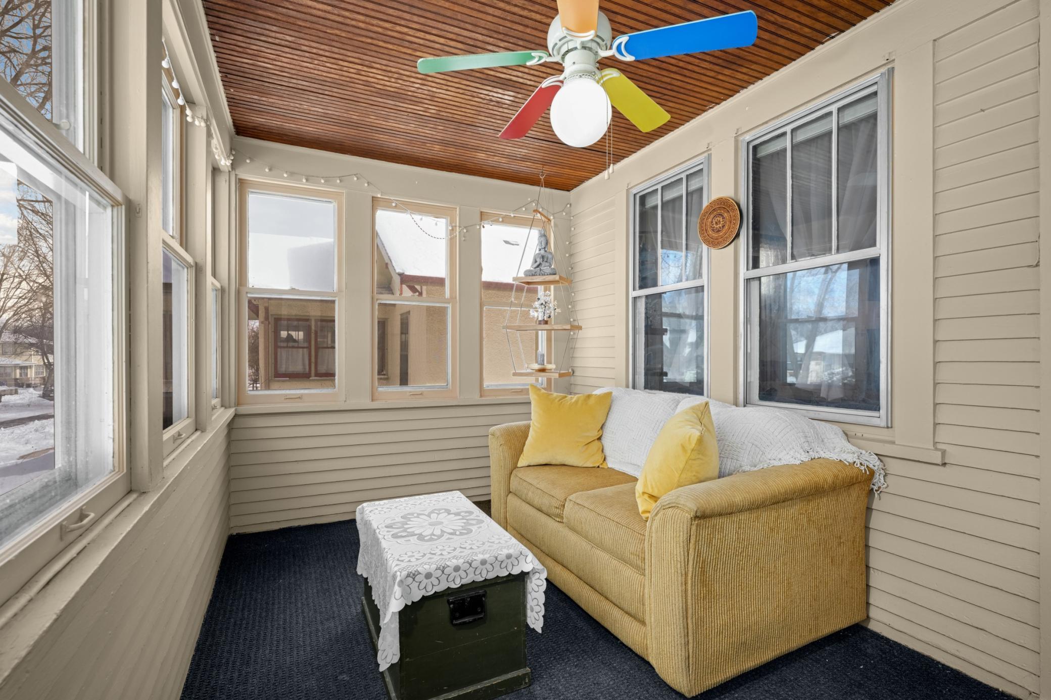 Spacious, enclosed 3-season porch with beadboard ceiling and fan