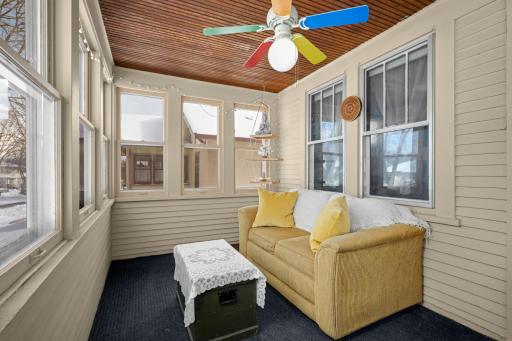 Spacious, enclosed 3-season porch with beadboard ceiling and fan