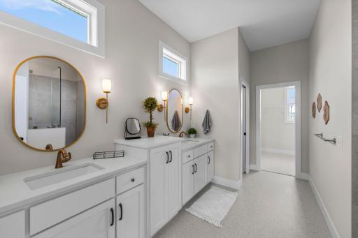 Enter the spa-inspired ensuite bathroom through a sleek pocket door, where you'll find a dual quartz vanity, a beautifully tiled walk-in shower, and a separate water closet for added privacy.
