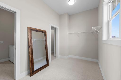 Continue through to the spacious walk-in closet, which connects directly to the main-floor laundry room, simplifying your daily routine.