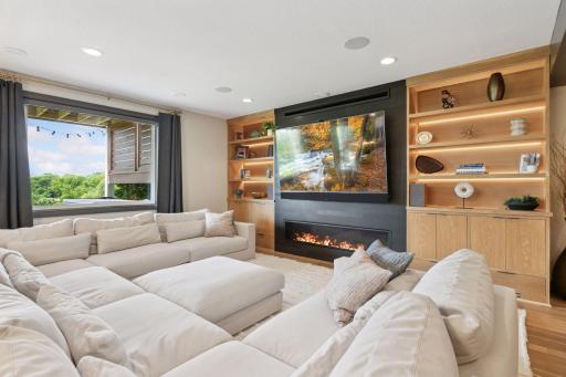 The incredible entertainment center features a gas fireplace, shelving with tasteful lighting, and can fit up to a 85' TV.