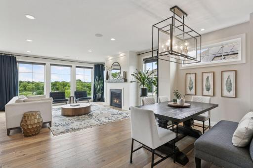 The formal dining area is highlighted by a modern light fixture and flows seamlessly into the living room and kitchen.