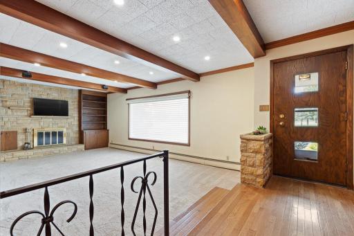 A couple of steps down to a cozy sunken living room with a striking stone fireplace and large picture window with full views of the golf course across the road!