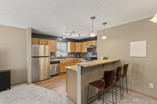Stunning kitchen that is open for entertaining! Stainless steel appliances, tile backsplash, new lighting and granite countertops. Love this breakfast bar.
