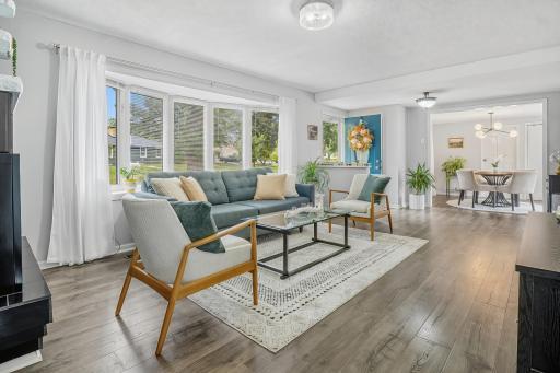 Living room, with one fireplace and huge bay window.