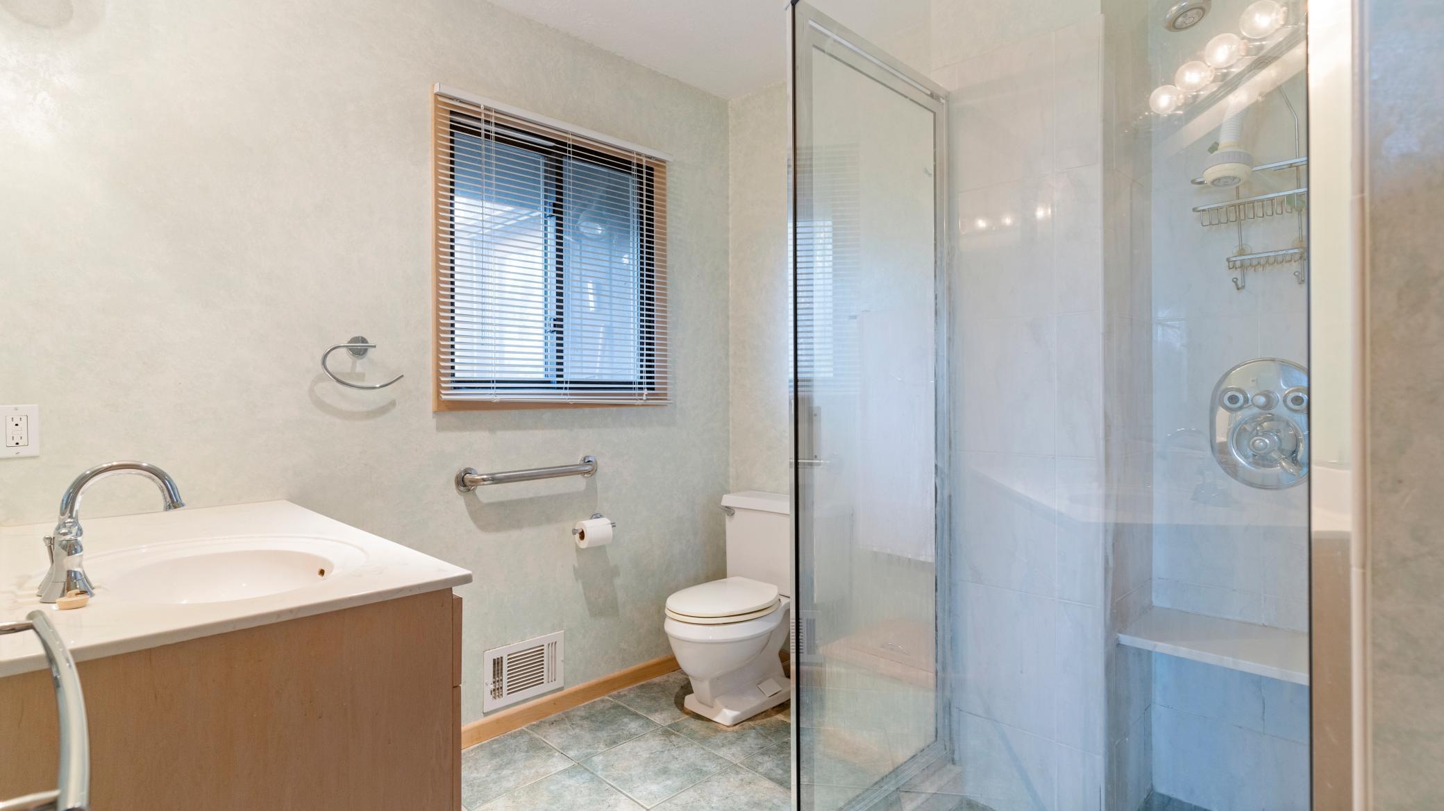 Large primary bathroom with heated tiled floors, walk-in shower with seat..