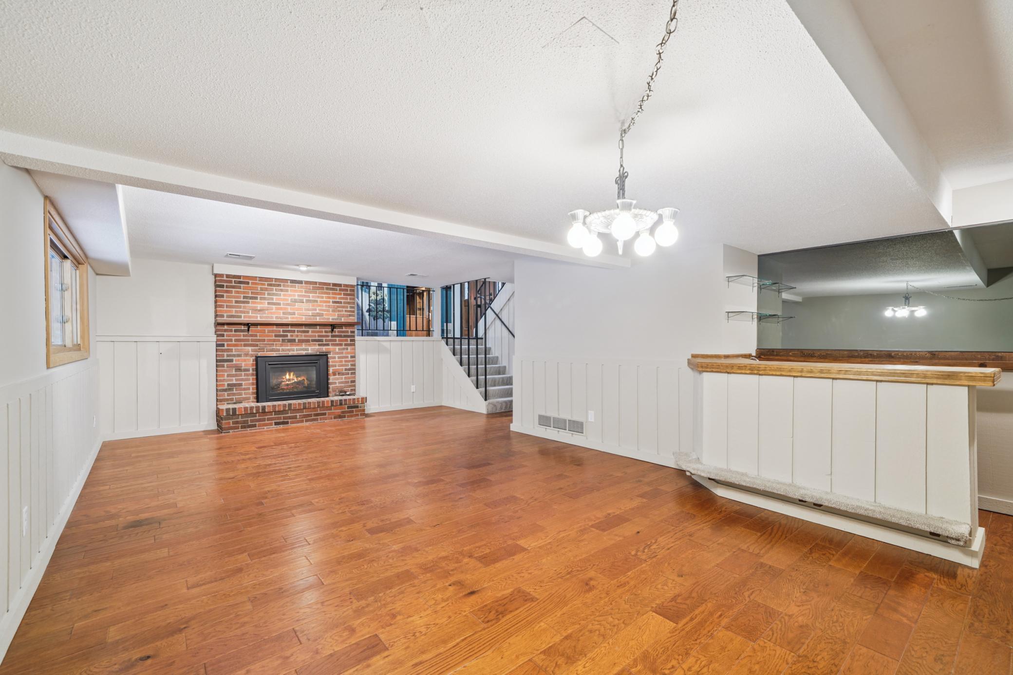 Huge LL family space looking back towards fireplace. Has wet bar to the right.