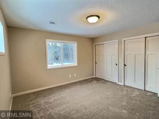 Primary bedroom includes dual closets and private bath with a walk in shower. Bedroom is located on the back side of the home overlooking the park and green space.