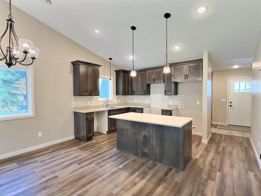 Kitchen includes quartz counter tops, walk in pantry and ample cabinets. Behind the kitchen is large closet and the laundry room.