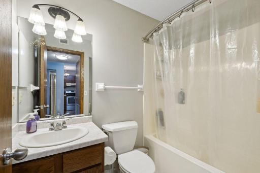 Full bath with a well sized tub, a linen closet (not seen but in the mirror) and built in medicine cabinet to your left.