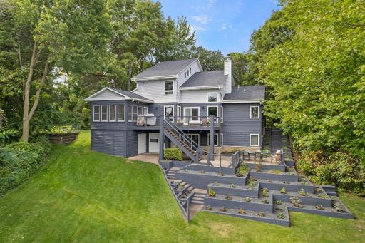 Amazing Multilevel Back of Home with Large Deck & Patio surrounding by numerous perennials