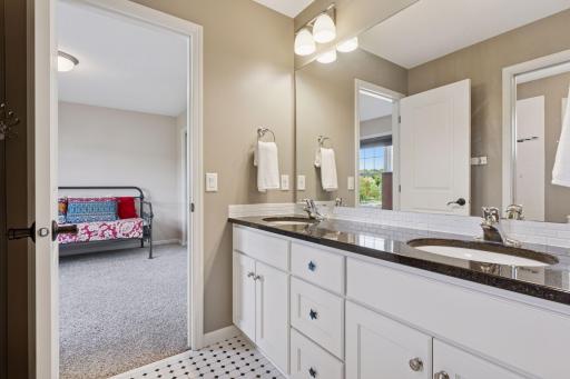 Jack-n-jill bathroom has a separate toilet and shower room divided by a door and separate room with double sinks.