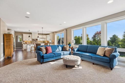 The sliding doors between the living room and kitchen provide access to the dining on the deck while the wall of windows floods both rooms with natural light.