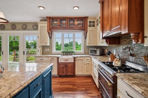 Custom farmhouse sink, pot filler above cooktop and tasteful backsplash.